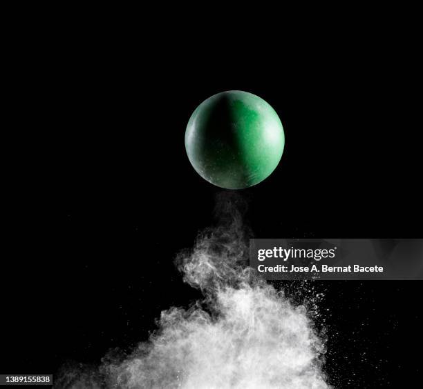 impact and rebound of a toy ball on a surface of land and powder on a black background - ballon rebond stock pictures, royalty-free photos & images