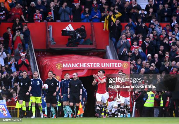 Harry Maguire of Manchester United leads their side out onto the pitch prior to the Premier League match between Manchester United and Leicester City...