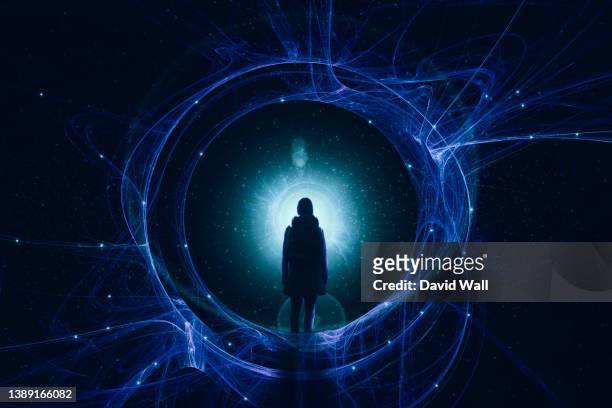 a fantasy, science fiction concept of a woman standing in front of a glowing mystical portal. in a universe of stars. - spirituality stock-fotos und bilder