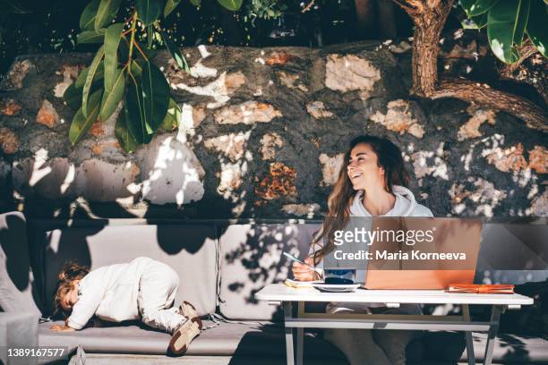young mother with her baby girl working on laptop at outdoors cafe. - daily life in turkey stock-fotos und bilder