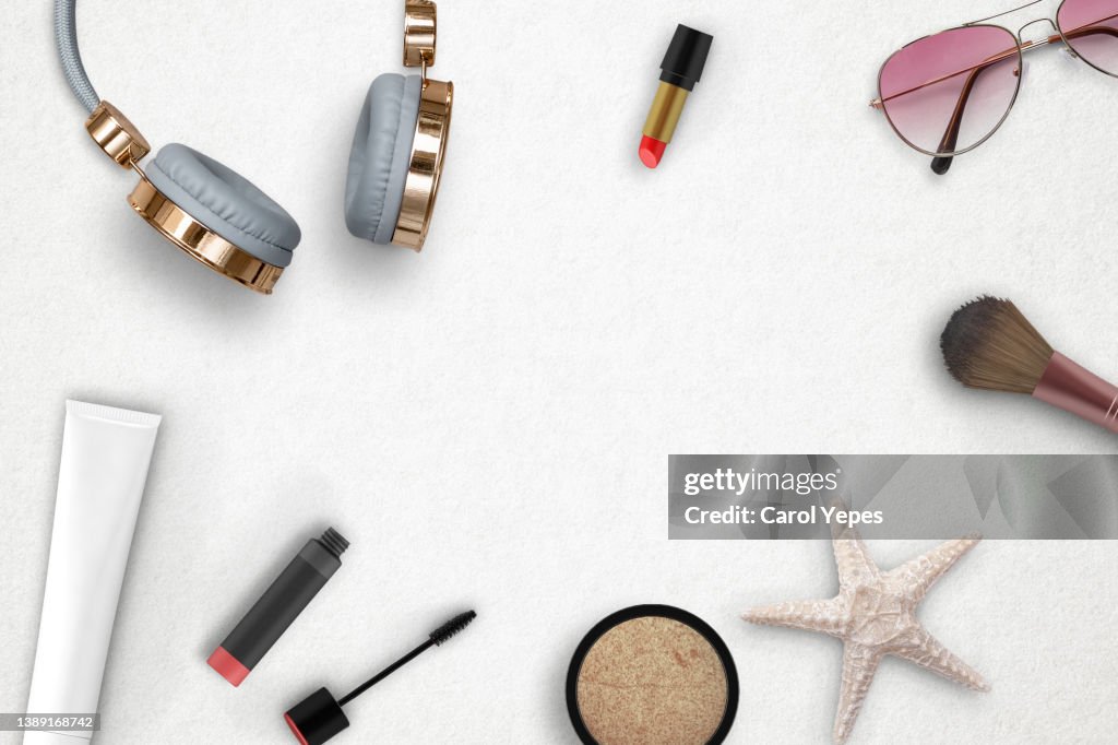 Stylish feminine flat lay table top still life. with headphones, summer items and beauty products