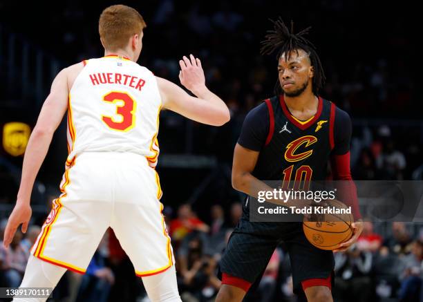 Darius Garland of the Cleveland Cavaliers looks to pass as he is guarded by Kevin Huerter of the Atlanta Hawks during the first half at State Farm...