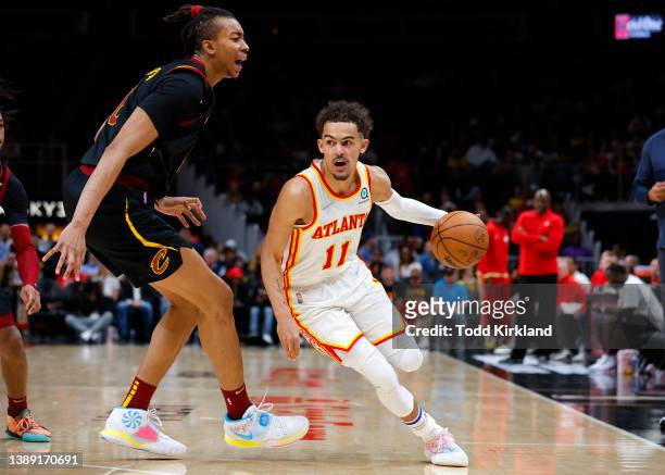 Trae Young of the Atlanta Hawks drives against Moses Brown of the Cleveland Cavaliers during the second half at State Farm Arena on December 19, 2021...