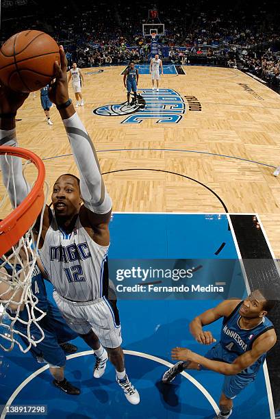 Dwight Howard of the Orlando Magic goes to the basket against Nikola Pekovic of the Minnesota Timberwolves as Wesley Johnson looks on during the game...