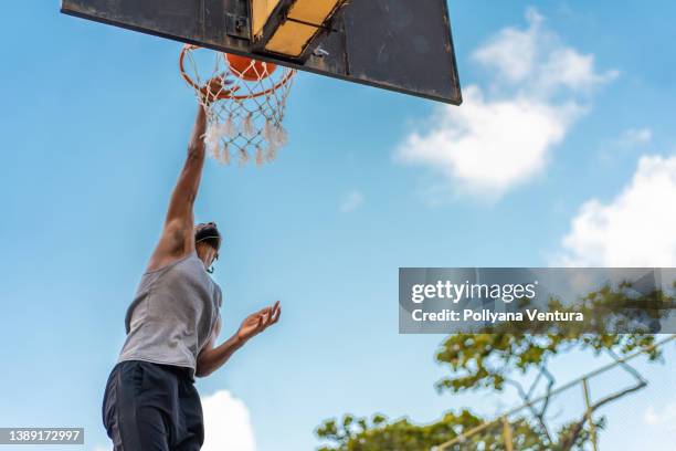 jogador de basquete pendurado na cesta de basquete - practicing - fotografias e filmes do acervo