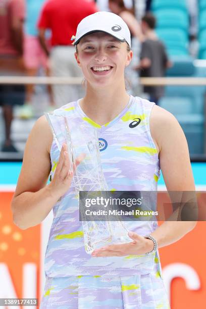 Iga Swiatek of Poland poses with the Butch Buchholz Trophy after defeating Naomi Osaka of Japan in the Women's Singles final during the Miami Open at...