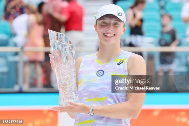 Iga Swiatek of Poland poses with the Butch Buchholz Trophy after defeating Naomi Osaka of Japan in the Women's Singles final during the Miami Open at...