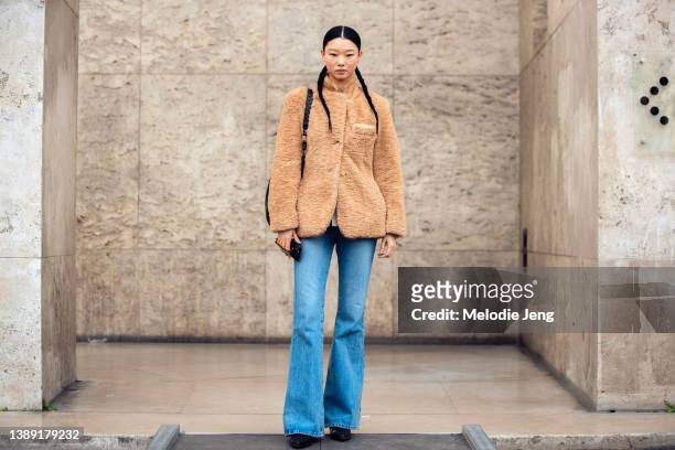 Yoon Young Bae wears a light brown fuzzy jacket, blue jeans, black boots after the Rochas show at Palais de Tokyo during Paris Fashion Week...