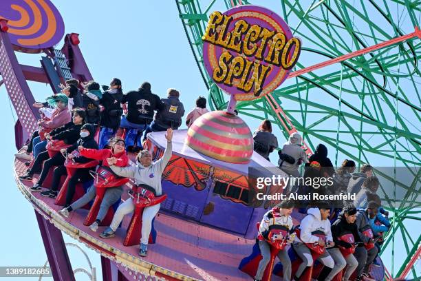 People ride the Electro Spin at Luna Park on the opening day of the season at Coney Island on April 2, 2022 in the Brooklyn Borough of New York City....