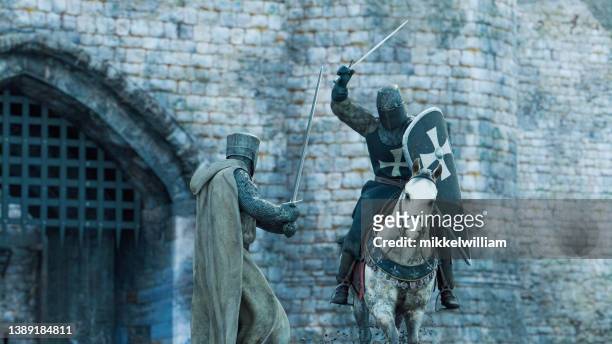 deux chevaliers se battent avec des épées devant un château - se battre photos et images de collection