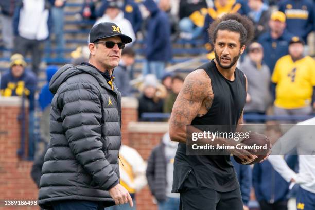 Colin Kaepernick interacts with Michigan Wolverine head coach Jim Harbaugh during a throwing exhibition during half time of the Michigan spring...