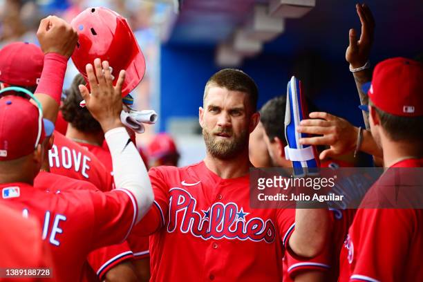 Bryce Harper of the Philadelphia Phillies celebrates with teammates after scoring in the first inning against the Toronto Blue Jays during a...
