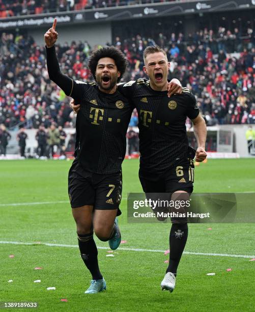 Serge Gnabry of FC Bayern Muenchen celebrates with teammate Joshua Kimmich after scoring their team's second goal during the Bundesliga match between...