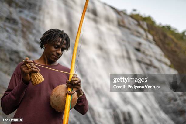 afro man playing berimbau - world music stock pictures, royalty-free photos & images