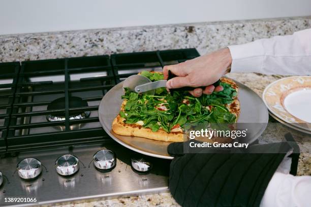 man slices vegetarian pizza - vegetarian pizza stock pictures, royalty-free photos & images