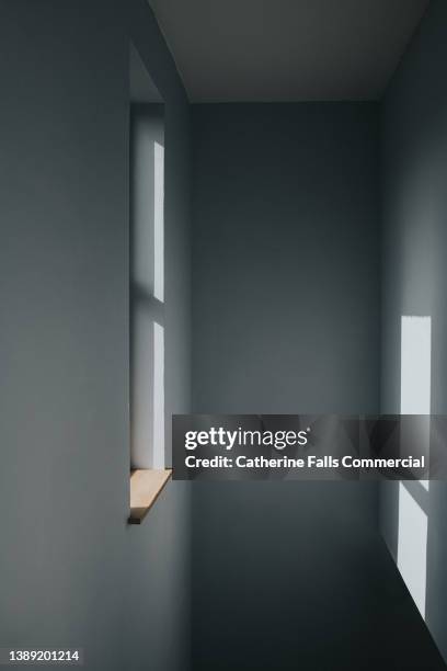 conceptual image of a single sunny window, with a sunbeam illuminating the wall opposite the pane of glass. - narrow stock pictures, royalty-free photos & images