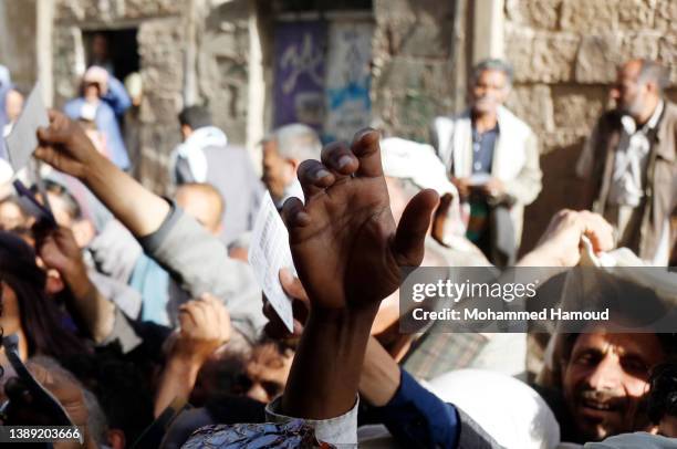 People affected by war wait to receive free meals provided by a charitable kitchen in the Mseek area on April 02, 2022 in Sana'a, Yemen. A two-month...