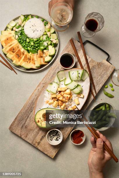 various vegan foods on green table, tofu, avocado, edamame rice with drinks - wabi sabi stock pictures, royalty-free photos & images