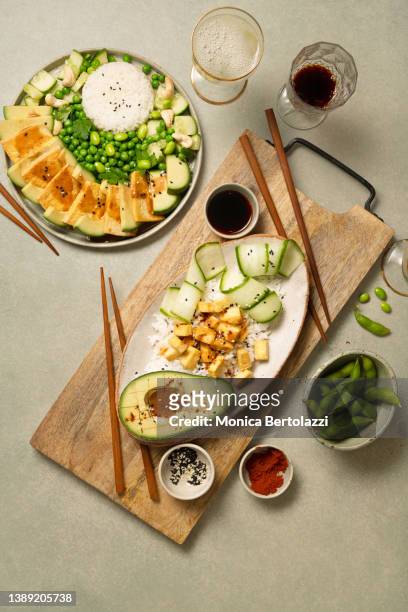 various vegan foods on green table, tofu, avocado, rice, edamame, with drinks - buffet fond stock-fotos und bilder