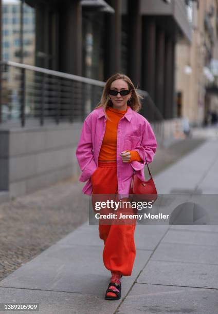 Sonia Lyson is seen wearing Chanel black sandals, Lumina orange jogging pants, Cashmere tie dye socks, Prada red Cleo leather bag, Zara orange...