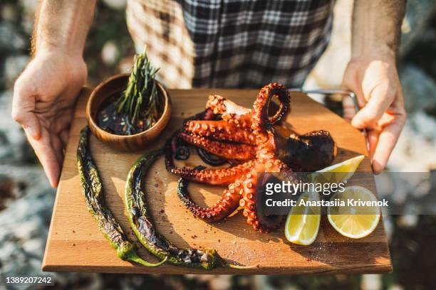 Close up of grilled octopus served on wooden tray.