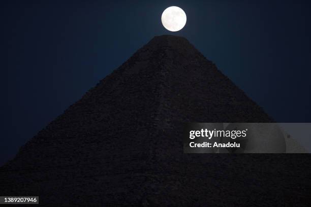 View of the Full Moon behind the Pyramids of Giza in Egypt on July 02, 2023.