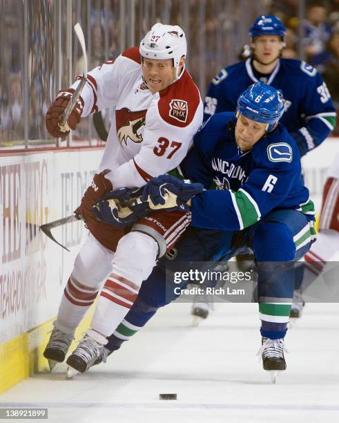 Sami Salo of the Vancouver Canucks tries to hold up Raffi Torres of the Phoenix Coyotes while chasing a loose puck during the first period in NHL...