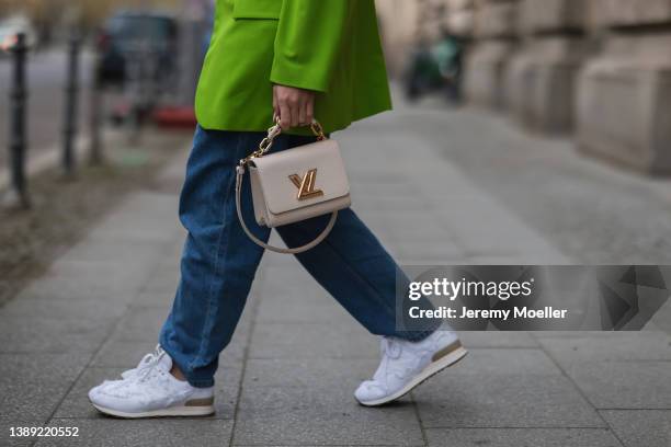 Sonia Lyson is seen wearing Miu Miu x New Balance white denim 574 sneaker, Boss blue denim jeans, Louis Vuitton mini twist leather beige bag, Zara...