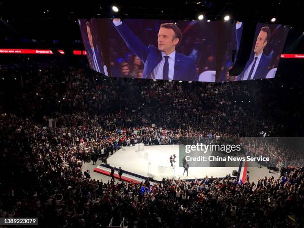 Large screens show French President and liberal party La Republique en Marche candidate for re-election Emmanuel Macron during a campaign meeting at...