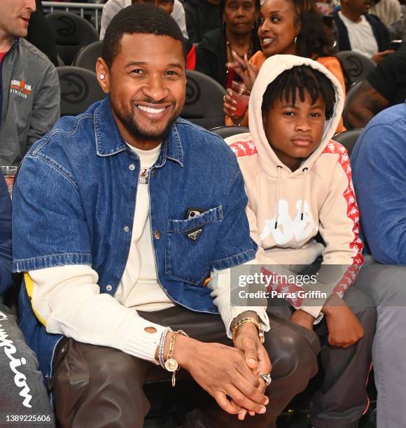 Usher Raymond and his son Usher Raymond V attend the game between Brooklyn Nets and the Atlanta Hawks at State Farm Arena on April 02, 2022 in...