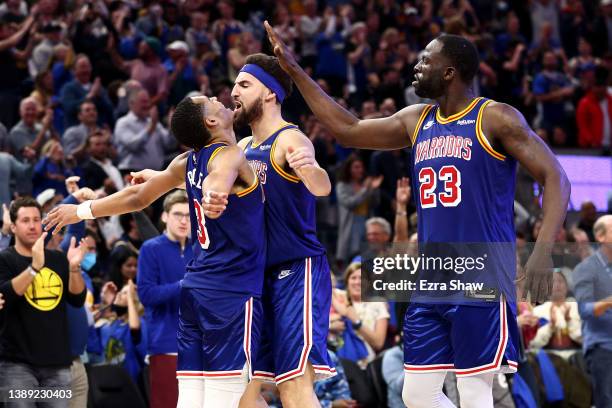 Jordan Poole of the Golden State Warriors is congratulated by Klay Thompson and Draymond Green after making a three point basket against the Utah...