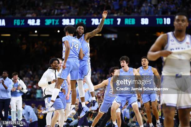 Puff Johnson and Dontrez Styles of the North Carolina Tar Heels celebrate after defeating the Duke Blue Devils in the semifinal game of the 2022 NCAA...
