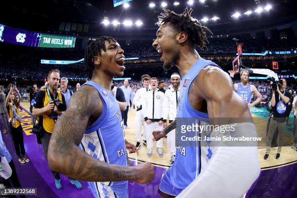Caleb Love and Leaky Black of the North Carolina Tar Heels celebrate a win against the Duke Blue Devils during the semifinal game of the 2022 NCAA...