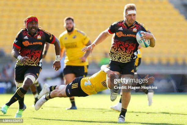 Sam Cane of the Chiefs is tackled by TJ Perenara of the Hurricanes during the round seven Super Rugby Pacific match between the Hurricanes and the...