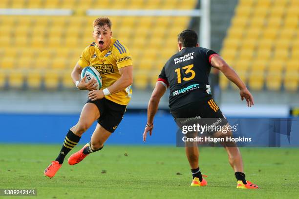 Ruben Love of the Hurricanes runs at Anton Lienert-Brown of the Chiefs during the round seven Super Rugby Pacific match between the Hurricanes and...