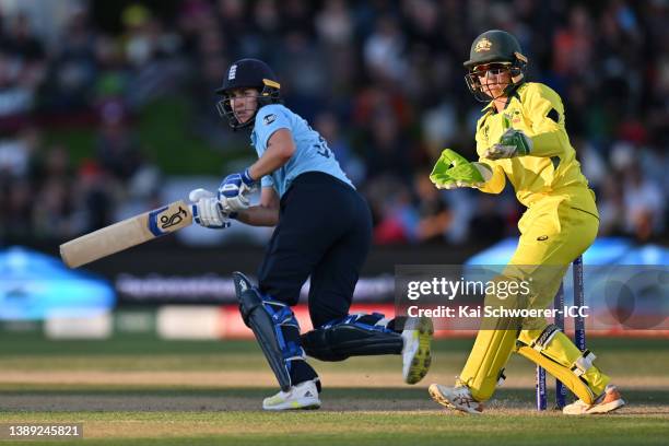 Alyssa Healy of Australia looks on after Natalie Sciver of England plays a shot during the 2022 ICC Women's Cricket World Cup Final match between...