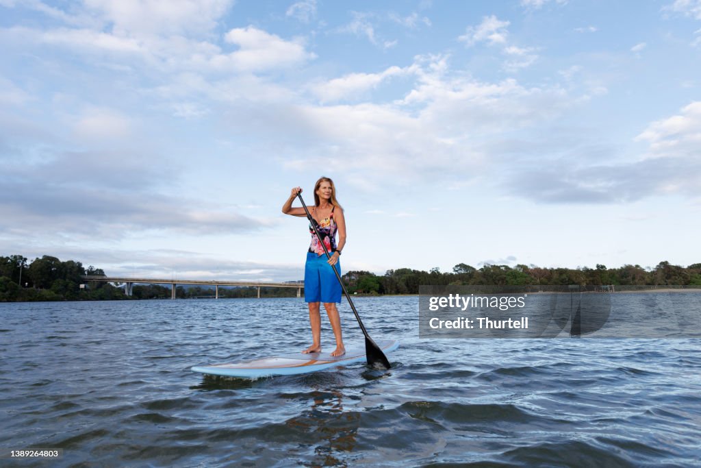 Mature Australian woman using stand up paddle board