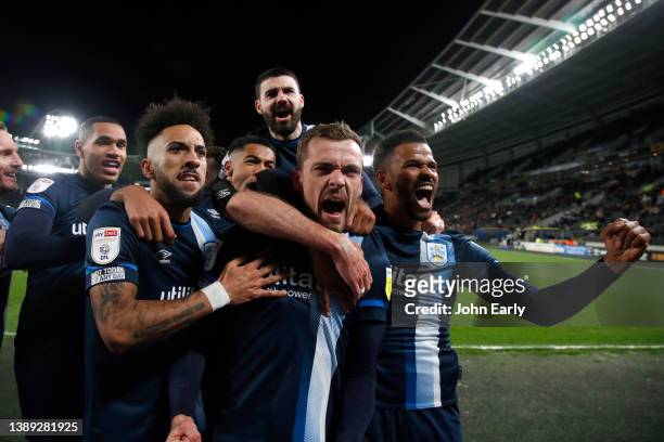 Harry Toffolo of Huddersfield Town celebrates with team mates including Sorba Thomas, Levi Colwill, Gonzalo Avila 'Pipa', and Fraizer Campbell after...