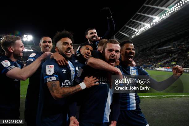 Harry Toffolo of Huddersfield Town celebrates with team mates including Sorba Thomas, Levi Colwill, Gonzalo Avila 'Pipa', and Fraizer Campbell after...