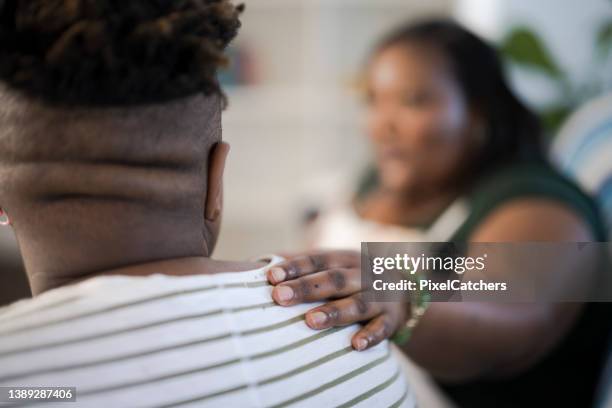 selective focus womans hand on friends shoulder - hand on shoulder stock pictures, royalty-free photos & images