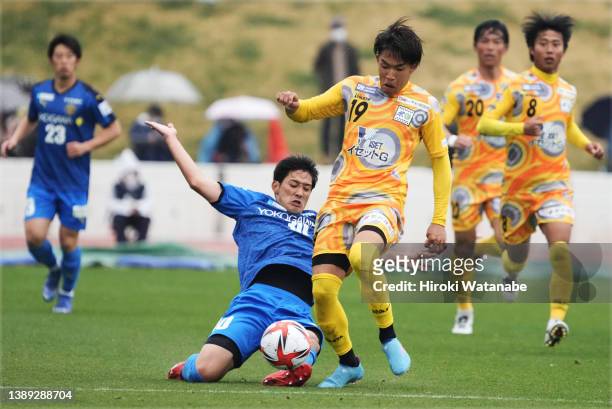 Taiga Suzuki of Tokyo Musashino United and Kaito Miyake of Suzuka Point Getters compete for the ball during the JFL match between Tokyo Musashino...