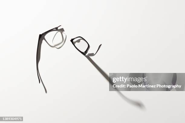 broken eyeglasses on white background - brille kaputt stock-fotos und bilder