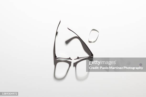 broken eyeglasses on white background - sombra paralela fotografías e imágenes de stock