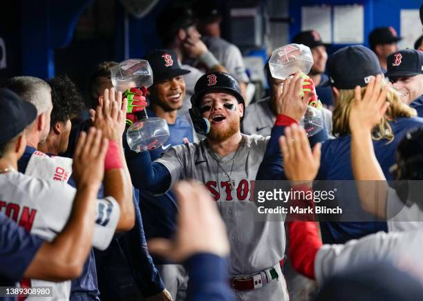 Alex Verdugo of the Boston Red Sox celebrates with teammates in the dugout after his home run during the ninth inning against the Toronto Blue Jays...