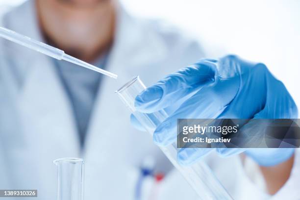 mikrobiologische forschung mit reagenzglas und mikropipette in nahaufnahme - laboratory stock-fotos und bilder