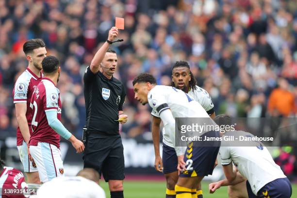 Referee Michael Oliver shows a red card to Michael Keane of Everton during the Premier League match between West Ham United and Everton at London...