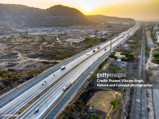modern multi lane national highway of india and a  railway track running parallel - national landmark stock pictures, royalty-free photos & images