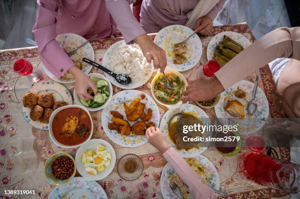 table top view of malay muslim family gathering and eating together during eid-fitr celebration - malay songkok stock pictures, royalty-free photos & images