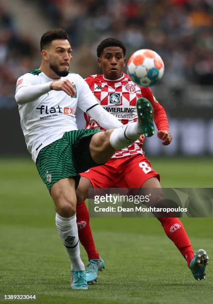 Ramy Bensebaini of Borussia Monchengladbach clears the ball past Leandro Barreiro of 1.FSV Mainz 05 during the Bundesliga match between Borussia...