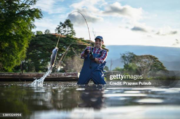 fishing at a lake - catch stockfoto's en -beelden